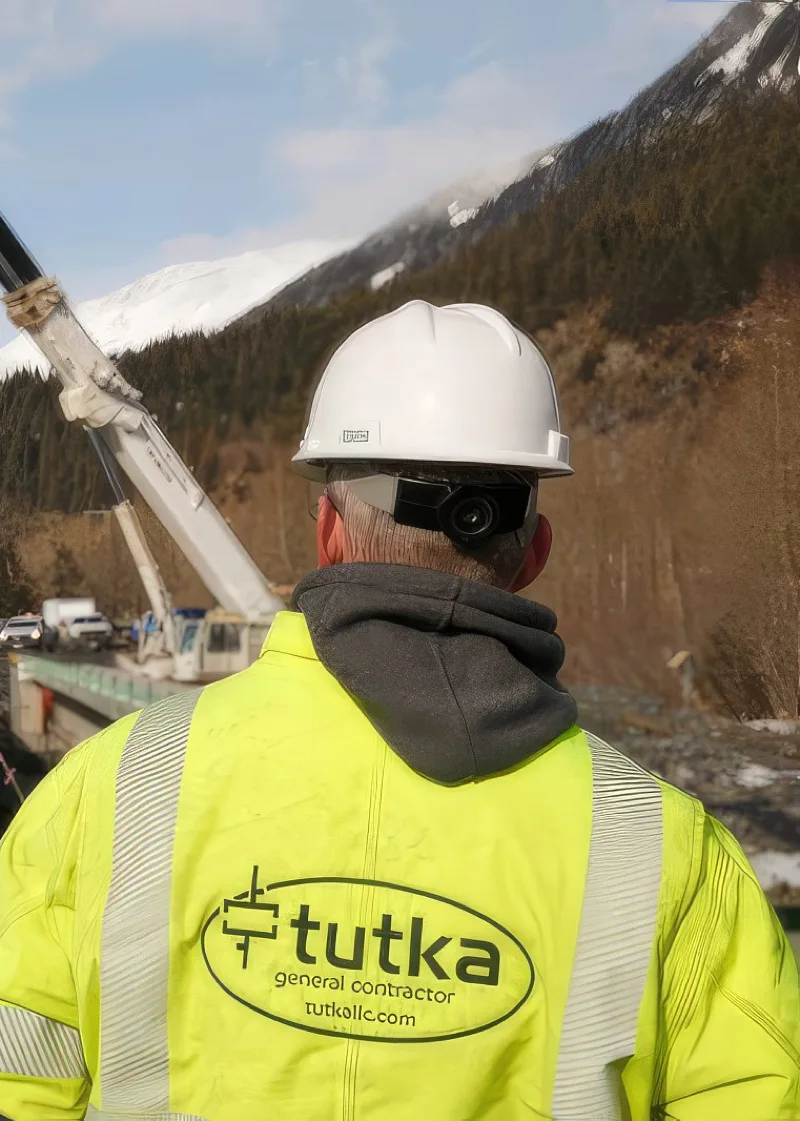 tutka general contractor with hardhat yellow coat at jobsite