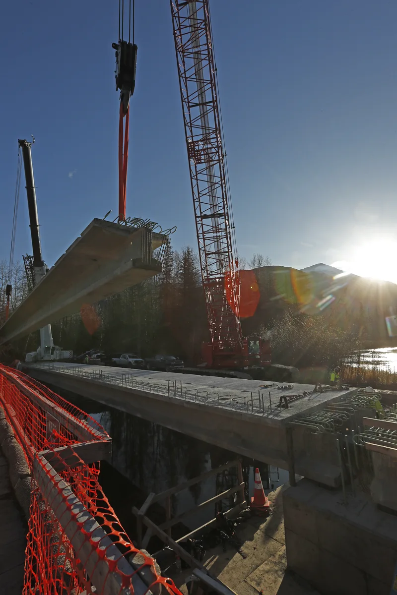 crane lifting girders on tutka highway project